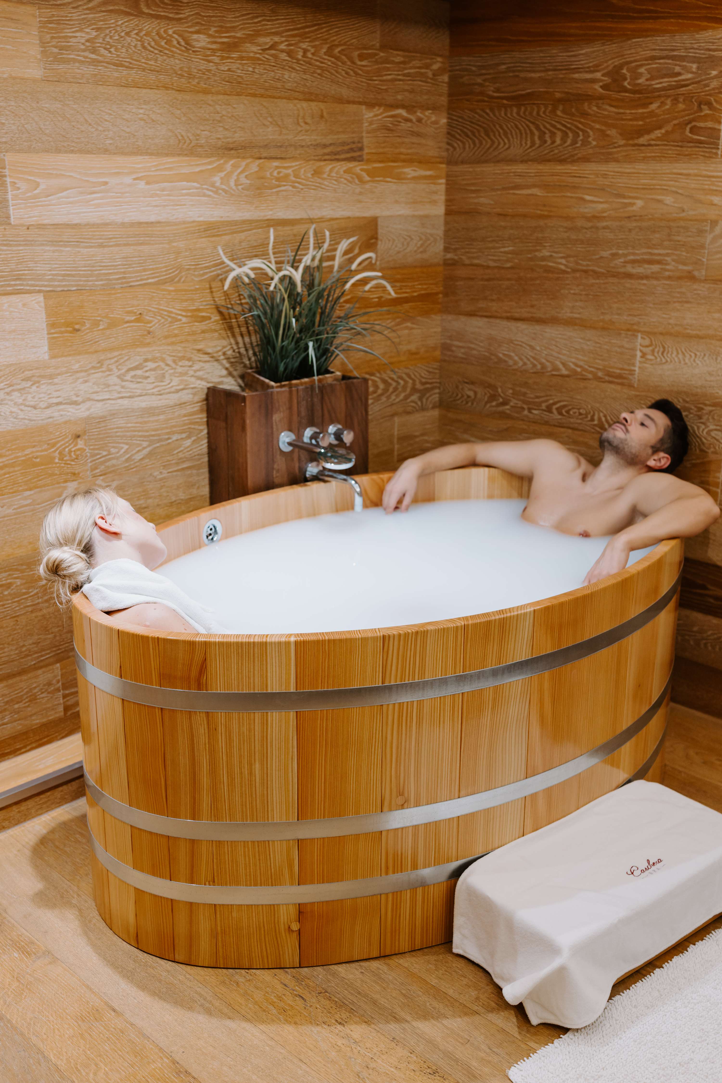 Coppia in vasca di legno stile botte con pannelli in legno naturale